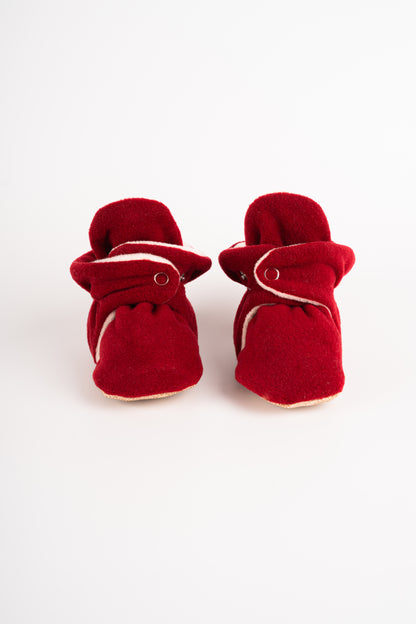 Comfortable and breathable baby booties in burgundy color with non-slip soles for safe adventures. Front view of burgundy pair.