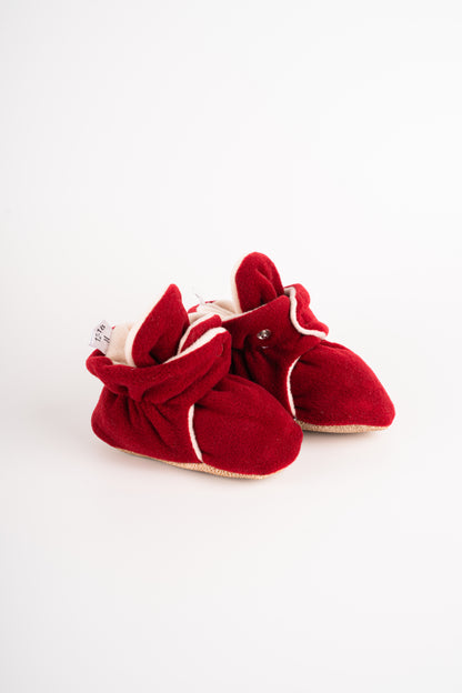 Comfortable and breathable baby booties in burgundy color with non-slip soles for safe adventures. Side view of burgundy baby booties pair.