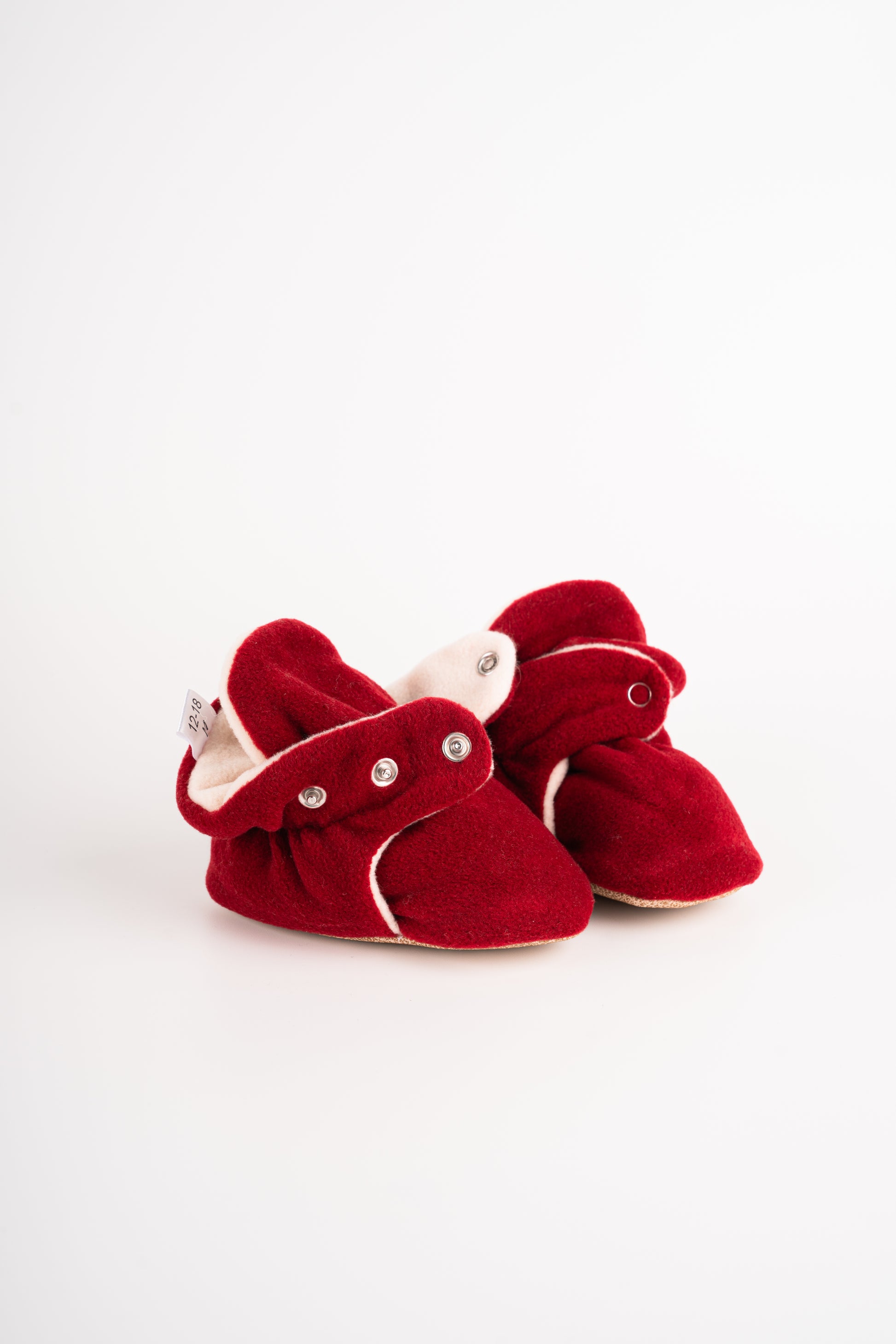 Comfortable and breathable baby booties in burgundy color with non-slip soles for safe adventures.  Side view of burgundy baby booties pair