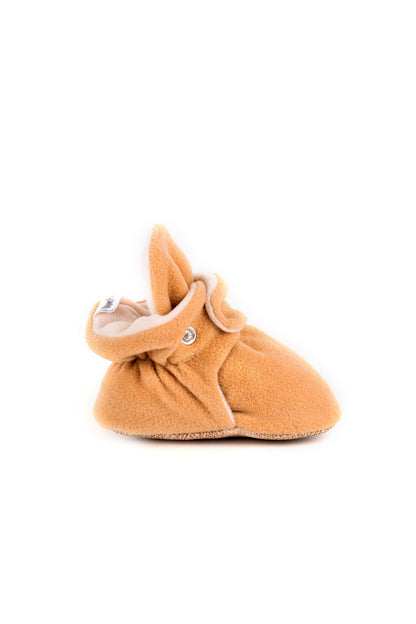 Comfortable and breathable baby booties in camel with non-slip soles for safe adventures. Left view.