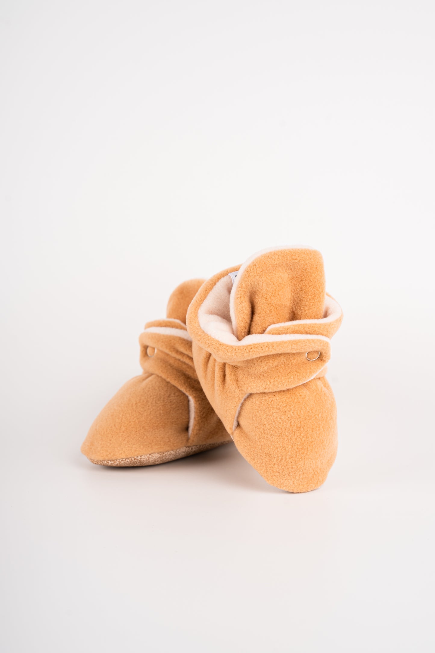 Comfortable and breathable baby booties in camel with non-slip soles for safe adventures. standing view.